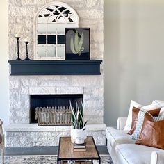 a living room filled with furniture and a fire place in front of a stone fireplace