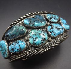 "VINTAGE NAVAJO BRACELET DESCRIPTION: This cuff features a dozen gorgeous specimens of natural old Kingman turquoise. The gemstones are secure in sawtooth bezel, on a foundation of heavy gauge vintage sterling silver. Twisted silver wire, applied leaves and raindrops, and chisel-notched designs embellish the breadth of the cuff. Don't overlook the turquoise cabs at each terminal. This bracelet will be a cherished addition to your collection of fine vintage Native American jewelry. MEASUREMENTS: Vintage Navajo Jewelry, Hand Candy, Vintage Native American Jewelry, Southwestern Art, Silver Turquoise Jewelry, Turquoise Jewelry Native American, Jewelry Turquoise, Gold Chains For Men, Navajo Jewelry