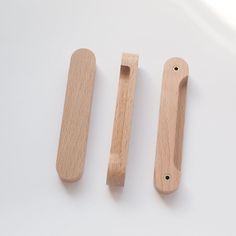 two wooden handles are shown next to each other on a white surface, one has a hole in the middle