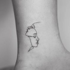 a woman's foot with a line drawing of a face on the side of her ankle