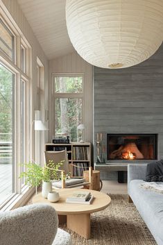 a living room filled with furniture and a fire place next to a large glass window