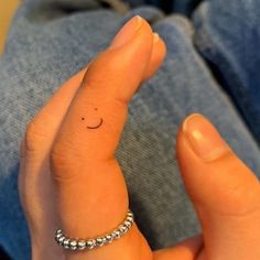 a person's finger with a smiley face drawn on it