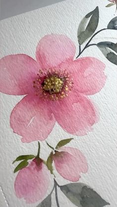 a pink flower painted on white paper with green leaves