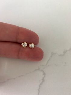 "14K Bezel Heart Earrings, Dainty Earrings, Women Earrings, Kid Earrings, Solid Gold Heart Bezel Earrings, Gold Hearts, Gold Heart Earrings ♦ Materials: 14kt Solid Gold, Stone: Cubic Zirconia ♦ Available colors: Clear Cubic Zirconia on Yellow Gold ♦ Closure: Screw Backs ♦ Earrings Measurements:5x5 (WxH) Millimeters in diameter -------------------------------------------------- ♦ -------------------------------------------------- PRODUCTION TIMES Order processing time varies between 1-2 business Heart Earrings For Anniversary, Dainty Bezel Set Earrings For Anniversary, Anniversary Heart Earrings For Pierced Ears, Heart Cut Earrings With Heart Beads For Anniversary, Dainty Heart Cut Earrings For Valentine's Day, Heart Cut Birthstone Earrings For Anniversary, Gold Heart Birthstone Earrings For Valentine's Day, Heart-shaped 14k Gold Birthstone Earrings, 14k Gold Heart Earrings With Birthstone For Anniversary