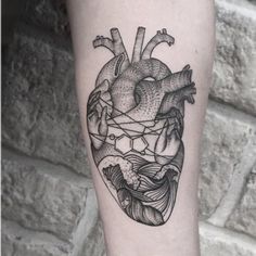 a black and white heart tattoo on the arm