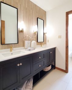 a bathroom with double sinks and two mirrors on the wall next to eachother