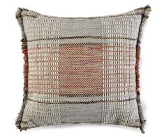 an orange and white pillow with fringes on the front, sitting on a white surface