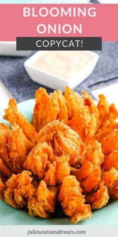 a blue plate topped with fried food next to a bowl of dipping sauce