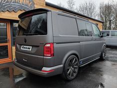 a grey van parked in front of a building