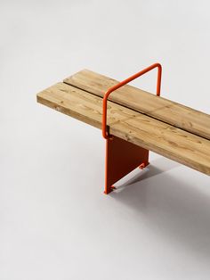 a wooden bench with an orange metal arm rests on a white surface, against a plain background