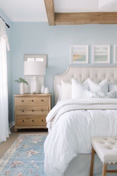 a bedroom with blue walls and white bedding