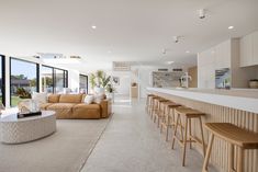 a living room filled with furniture next to a kitchen and an open concept dining area