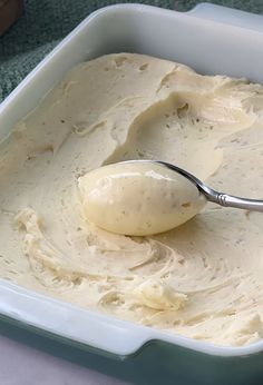 a spoon is in a white dish with cream