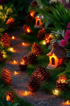 many pine cones are lit up in the grass with small houses and lights on them