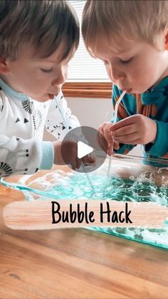 two young boys are playing with bubbles in the water