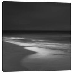 black and white photograph of the ocean with waves coming in from the shore at night