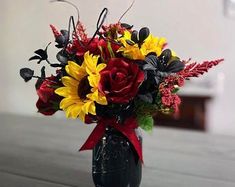 a vase filled with sunflowers and other flowers on top of a wooden table