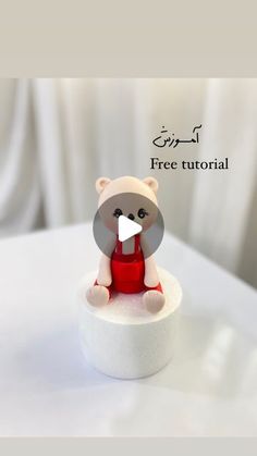 a small teddy bear sitting on top of a white table