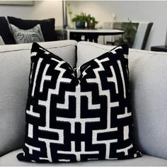 a black and white pillow sitting on top of a gray couch