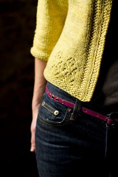 a woman wearing a yellow sweater and jeans