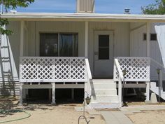 two white porches and steps in front of a house