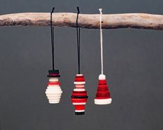 three red, white and black lights hanging from a tree branch