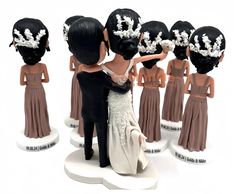 a bride and groom figurines standing next to each other in front of a group of people