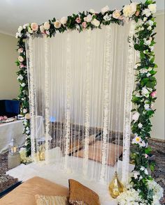 a bed sitting under a white curtain covered in flowers