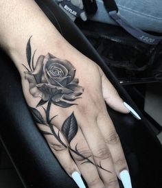 a woman's hand with a rose tattoo on it