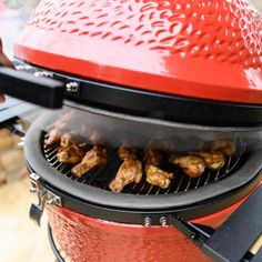 a red barbecue grill with chicken on it