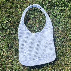 a crocheted bag laying in the grass