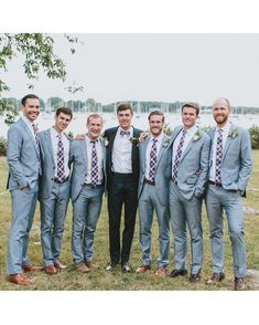 a group of men in suits standing next to each other on a lush green field