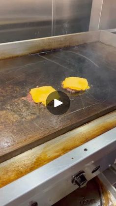 two pieces of cheese are being cooked on a grill in an industrial kitchen with stainless steel