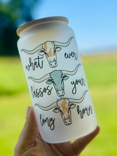 a hand holding up a cup with an image of a cow on it and the words, that's why you miss