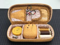 an open suitcase filled with different types of thread and sewing supplies on top of a table