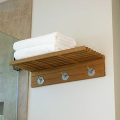 a wooden shelf with three towels on it