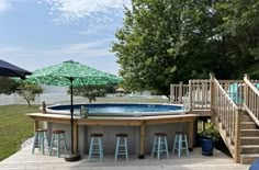 an above ground pool surrounded by stools and umbrella