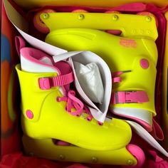 a pair of yellow and pink roller skates in a box with other items inside