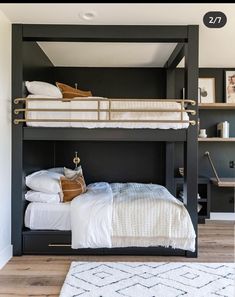 a black bunk bed with white sheets and pillows