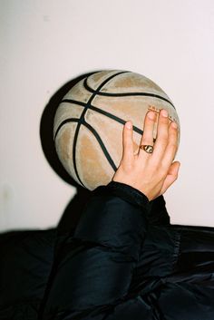 a person with their hand on a basketball in the shape of a ball over their head