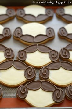 decorated cookies with chocolate and white icing on a baking sheet