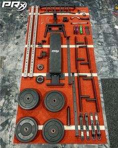 an assortment of gym equipment is displayed on a red mat