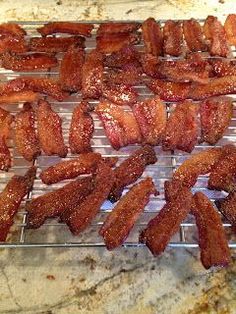 bacon is being cooked on a grill in the kitchen