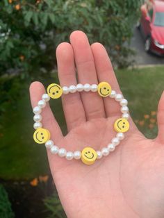 A pearl bracelet with yellow smiley faces on it Yellow Beaded Bracelets With Smiley Face, Smiley Face Bracelet, Yellow Smiley Face, Smiley Faces, Smiley Face, Pearl Bracelet, Arm Band, Smiley, Jewelry Bracelets