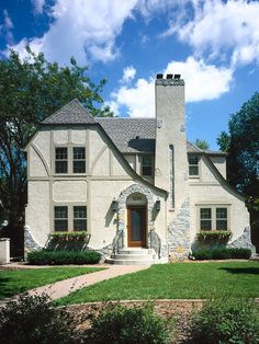 a large white house sitting on top of a lush green field