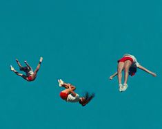 three people are in the air doing acrobatic tricks