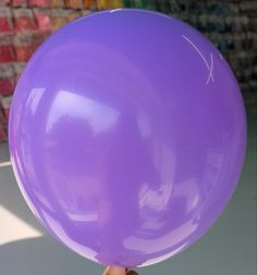 a person holding a large purple balloon in their hand