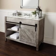 Add a rustic feel to your farmhouse bathroom with this barn door vanity in a beautiful gray. #barndoor #woodvanity #rusticdesign #farmhouse