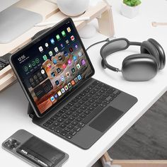 an open laptop computer sitting on top of a desk next to headphones and a mouse