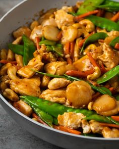 a pan filled with chicken and vegetables on top of a table